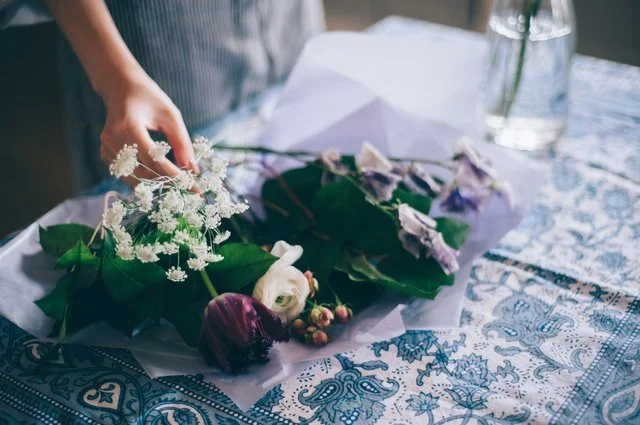 テーブルの花見本を囲んで装花の相談をする二人の手元